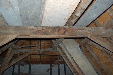 <p>Foto van de bovenste dekbalk van gebint nr 4 van het linker deel van het huis. Deze balk heeft een aantal pengaten die wijzen op een eerdere functie als makelaar van een 14e-eeuwse kap met een zogenaamd langsverband. </p>
